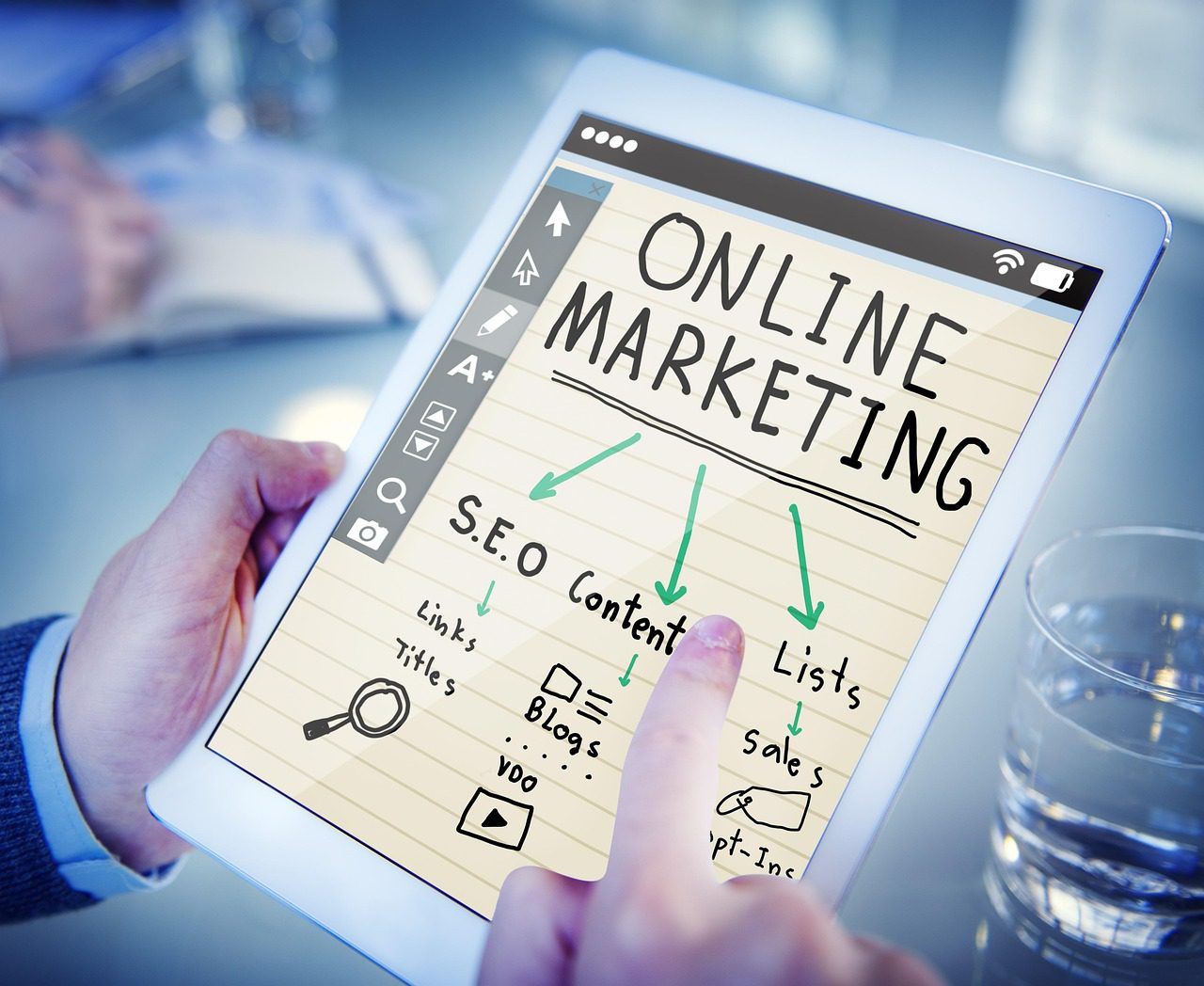 Pessoa segurando um smartphone e planejando a promoção de sua marca online em um ambiente de escritório moderno.