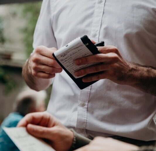 man in white button up shirt holding black and white box