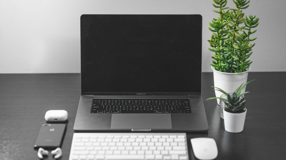 Setup de trabalho limpo e organizado com laptop e acessórios, ideal para demonstrar importância da limpeza com aspirador portátil USB