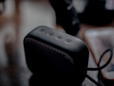 Caixa de som Bluetooth portátil ao lado de smartphone