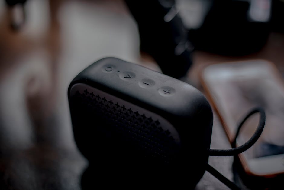 Caixa de som Bluetooth portátil ao lado de smartphone