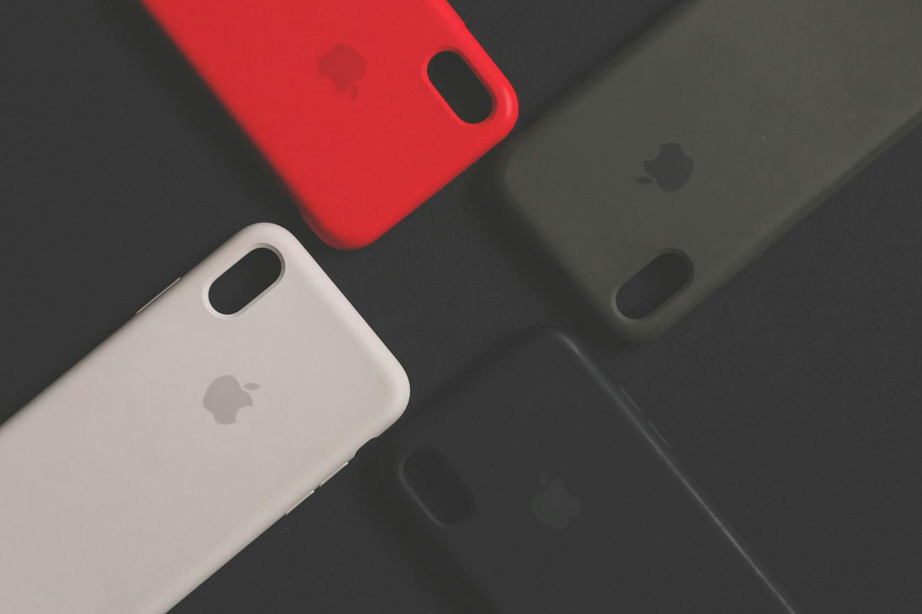 Capas de silicone coloridas para smartphone sobre superficie escura, mostrando variedade de protecao e estilo para celular