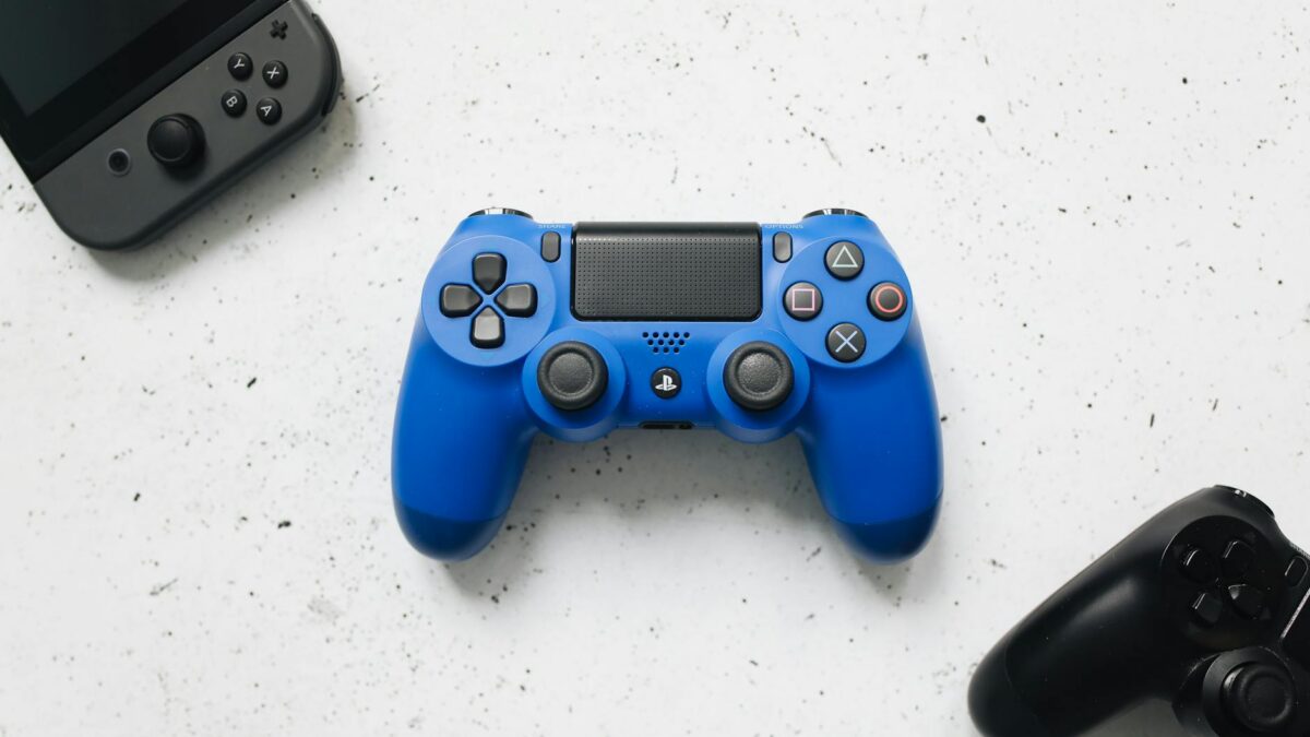Controles gamepad coloridos sobre superficie branca, representando os melhores controles sem fio para PC em 2026