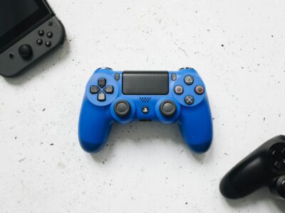 Controles gamepad coloridos sobre superficie branca, representando os melhores controles sem fio para PC em 2026