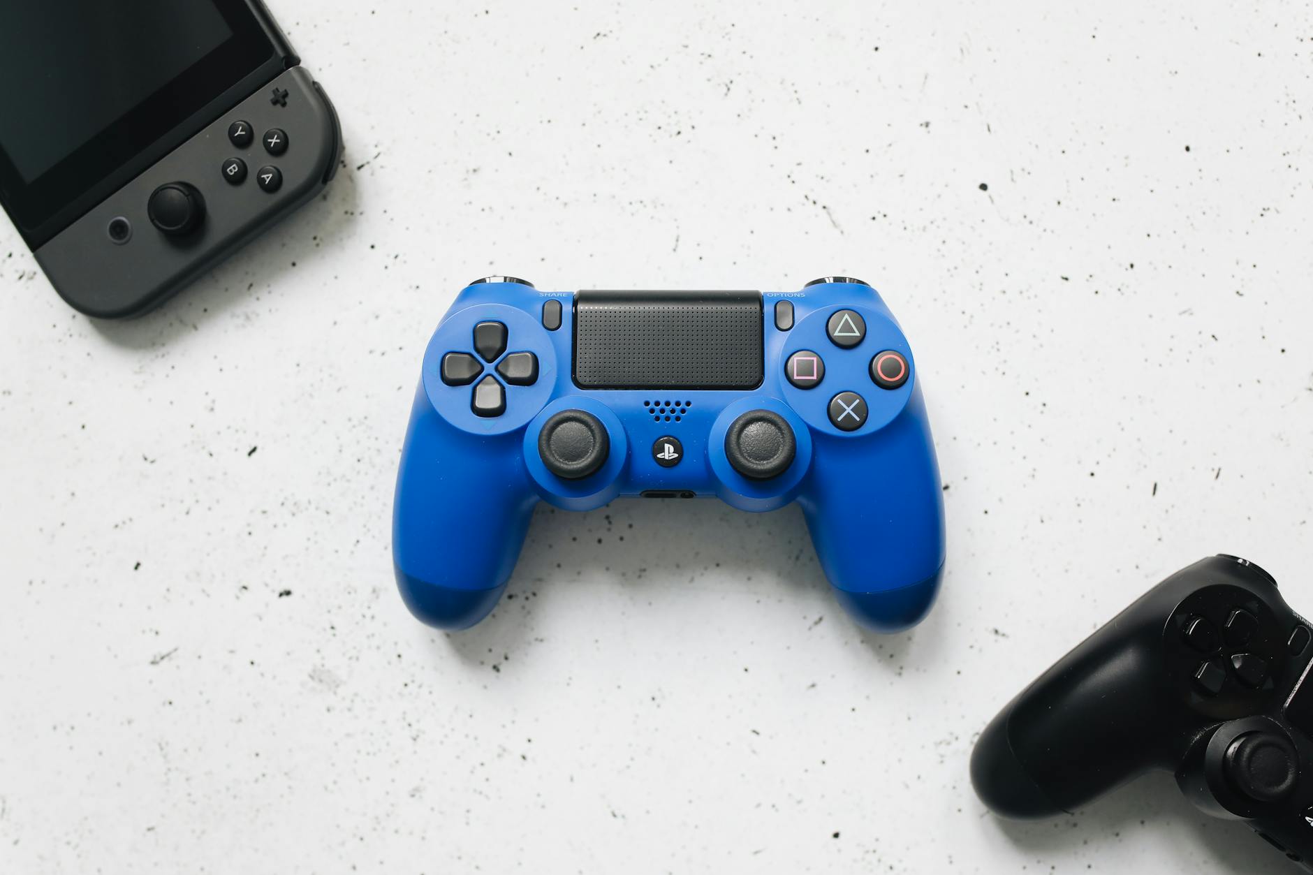 Controles gamepad coloridos sobre superficie branca, representando os melhores controles sem fio para PC em 2026