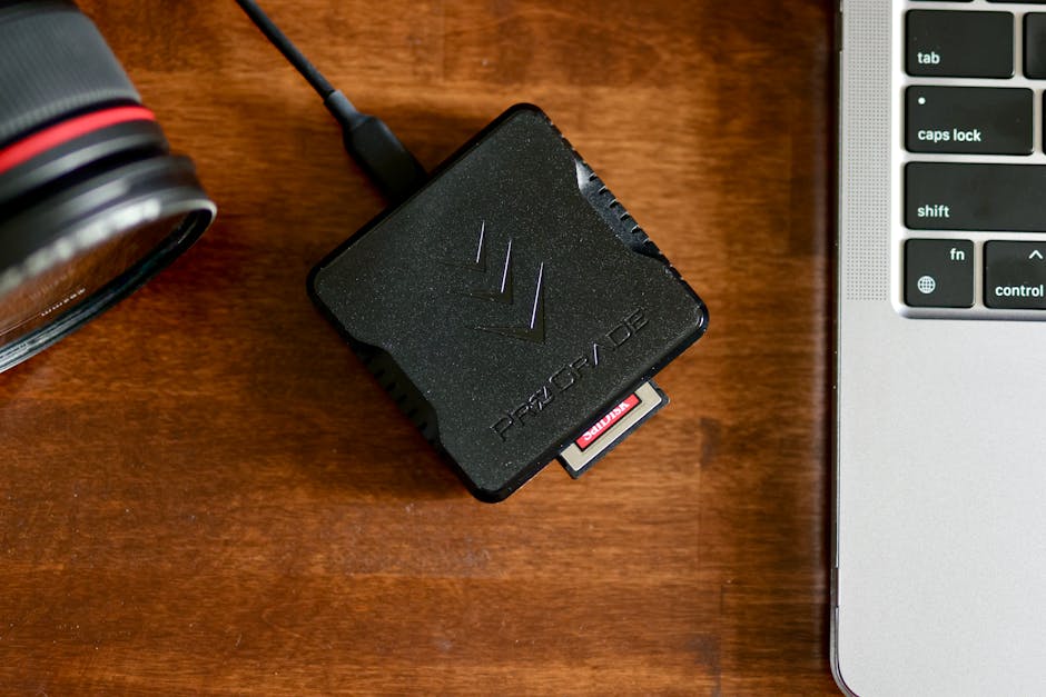 Leitor de cartão SD conectado a notebook com cartão de memória em mesa de trabalho