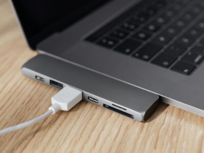 Hub USB-C multiportas conectado a laptop moderno sobre mesa de madeira, demonstrando conectividade para home office e produtividade