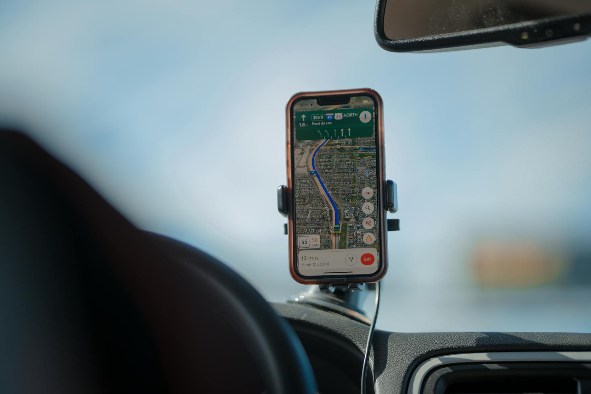 Smartphone com GPS montado em suporte veicular magnetico no painel do carro durante viagem, demonstrando navegacao segura ao volante