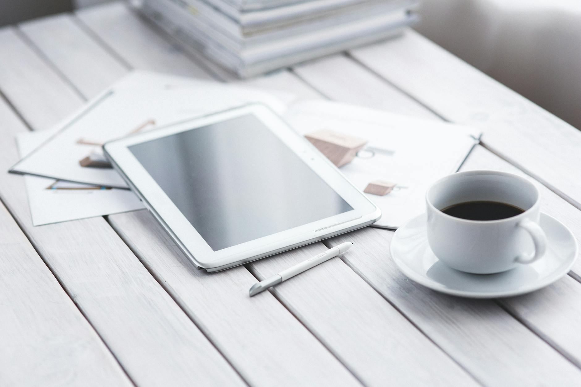 Tablet moderno com stylus e cafe sobre mesa de escritorio, demonstrando versatilidade para estudos, trabalho e lazer em 2026