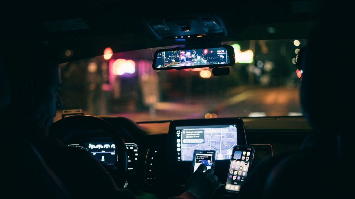 Motorista de aplicativo usando smartphone para navegacao no carro a noite